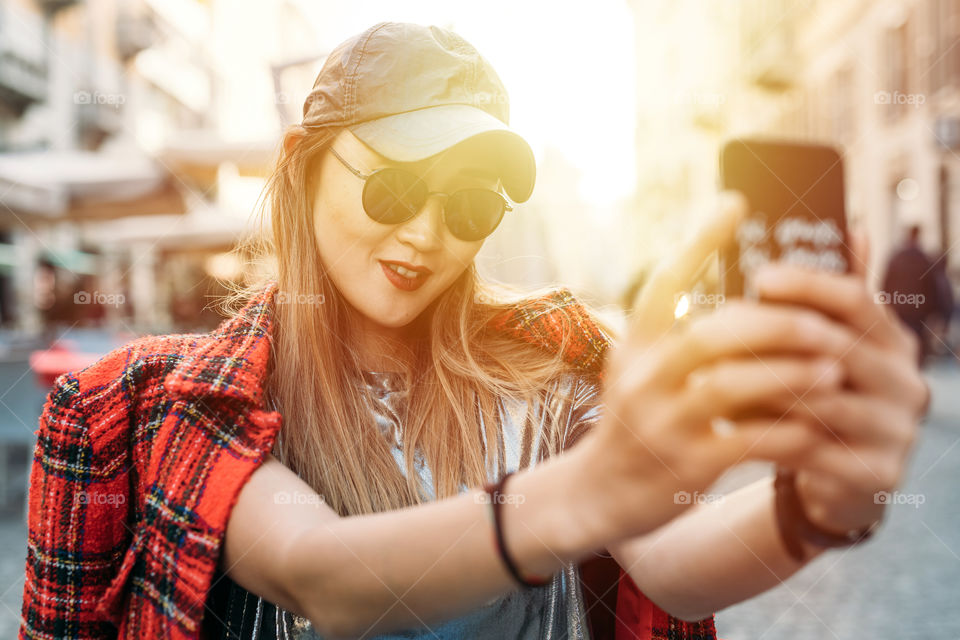 beautifull asian woman with sunglass taking selfie in the street outdoors - connection, social life, influencer