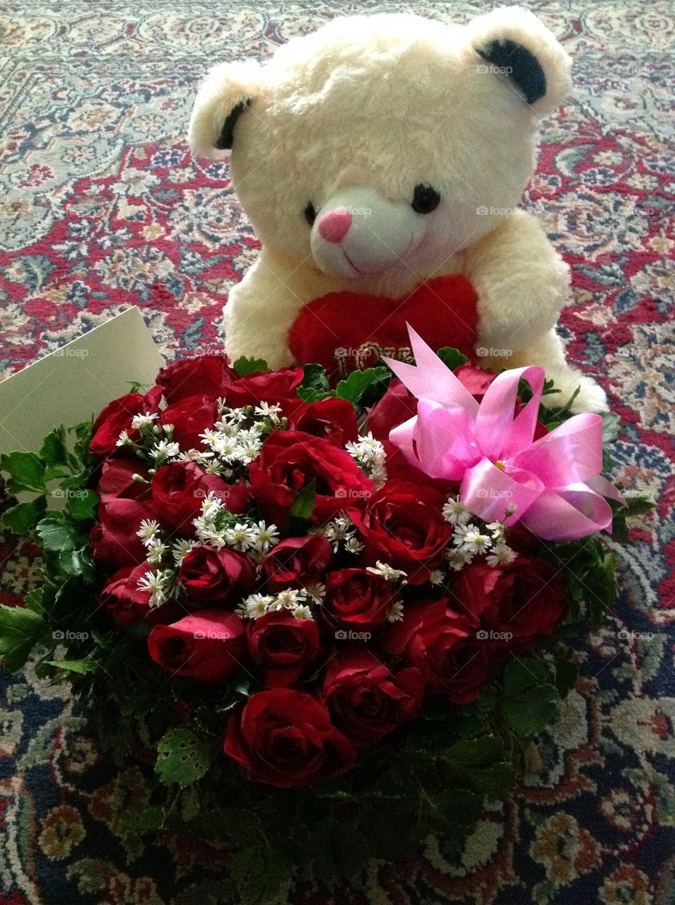 A delivery bear with roses and card.