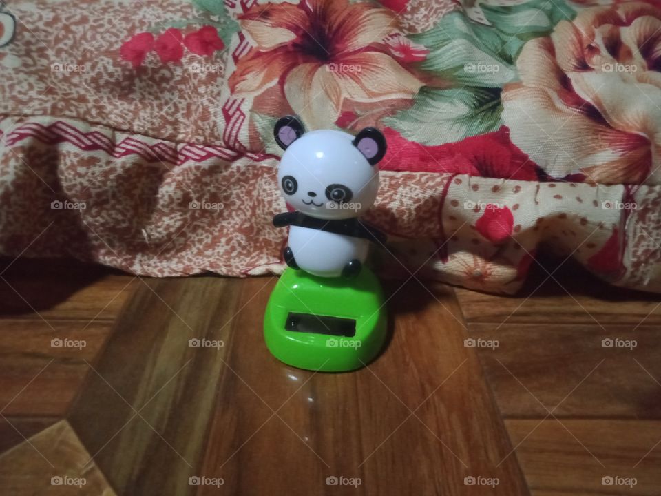 A panda toy near a pillow