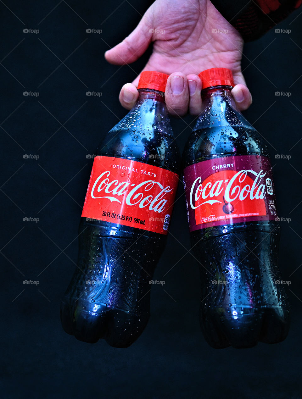 Close up shot of two Coca Cola with black background with the mists at the studio.  