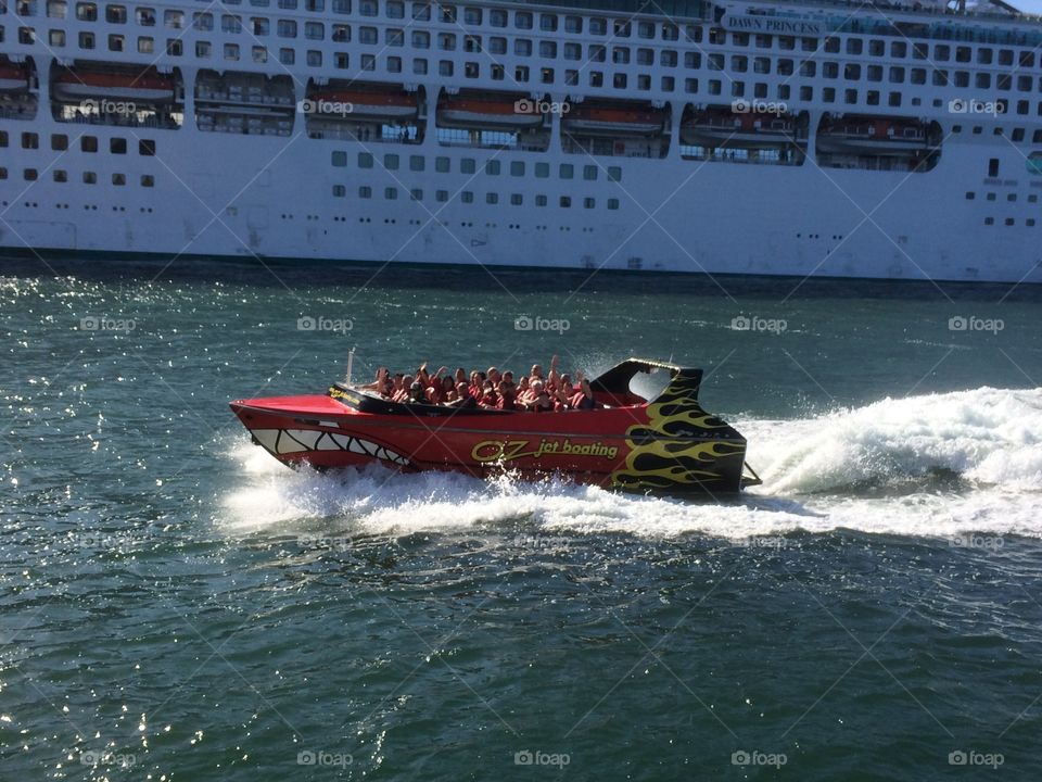 Jet boat on the harbour.  Jet boat passing a cruise ship, photo taken from a ferry 