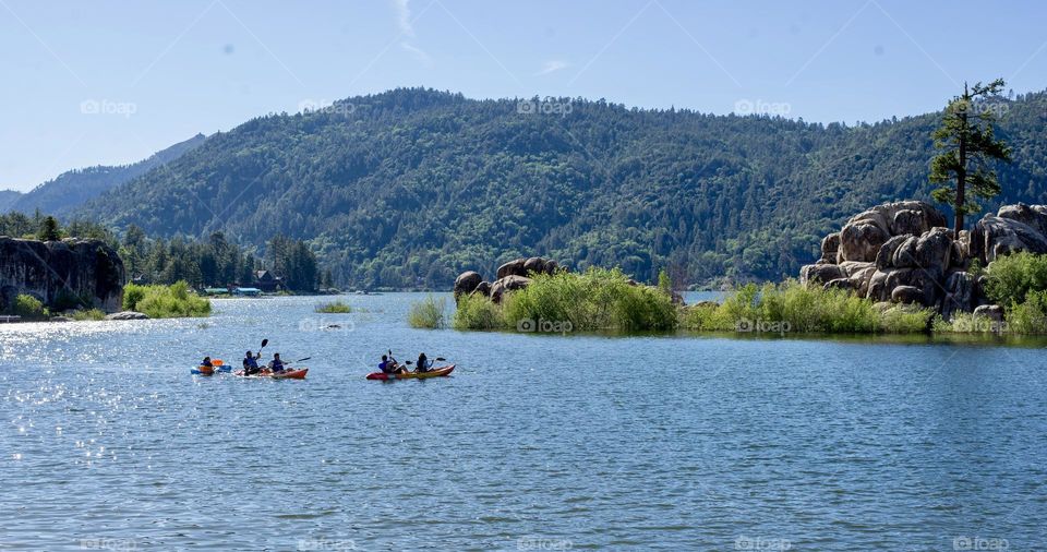 A quiet lake with people doing outdoor activities on a beautiful sunny day