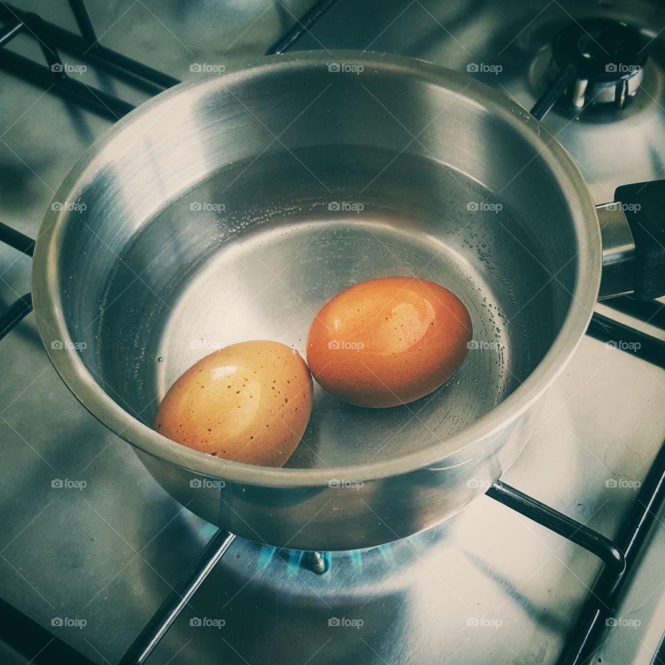 Two Brown Eggs Boiling In A Saucepan