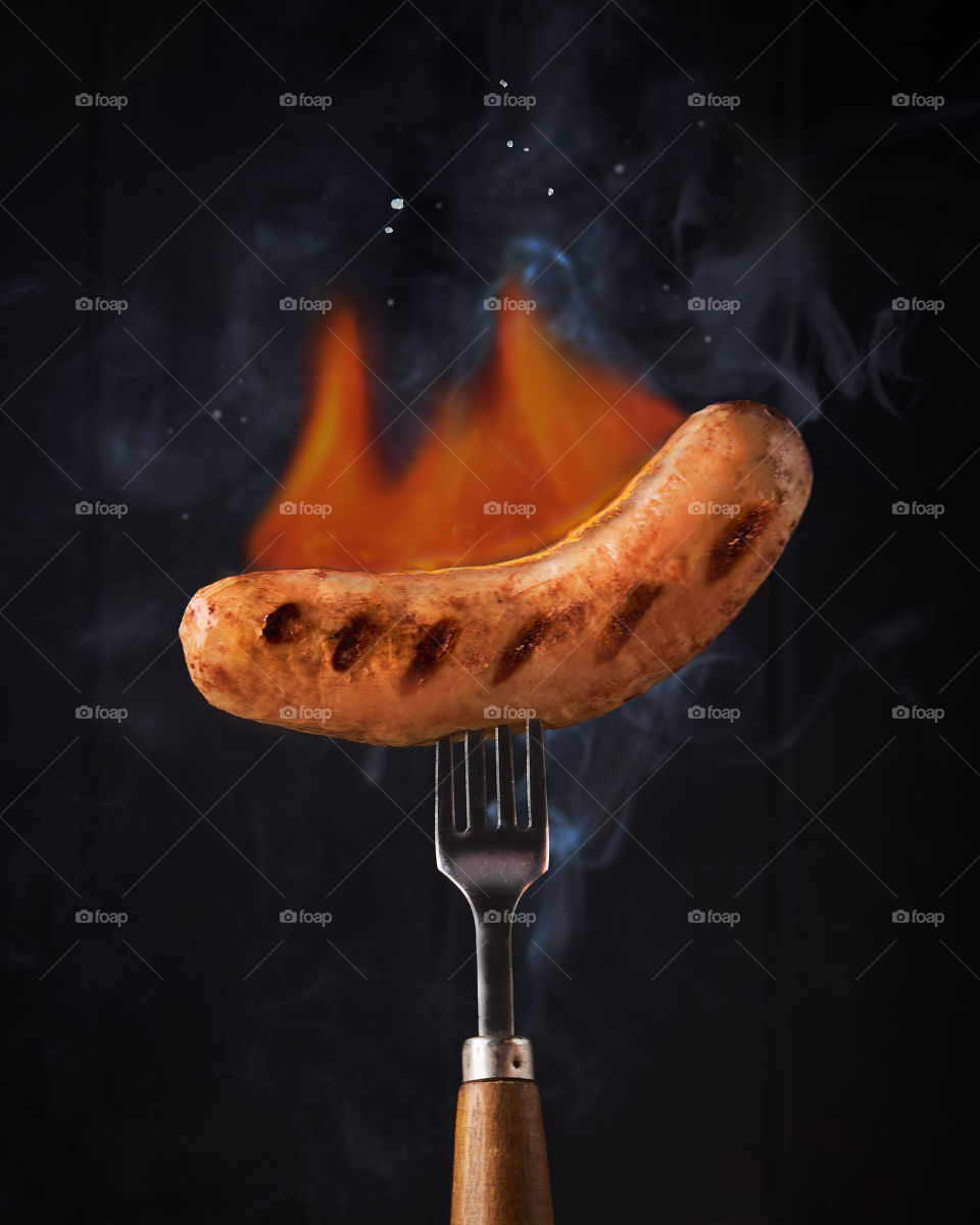 Hot Sausage on fork on fire