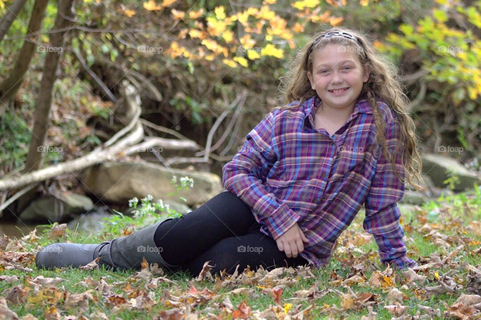 Pretty young lady by a stream. 