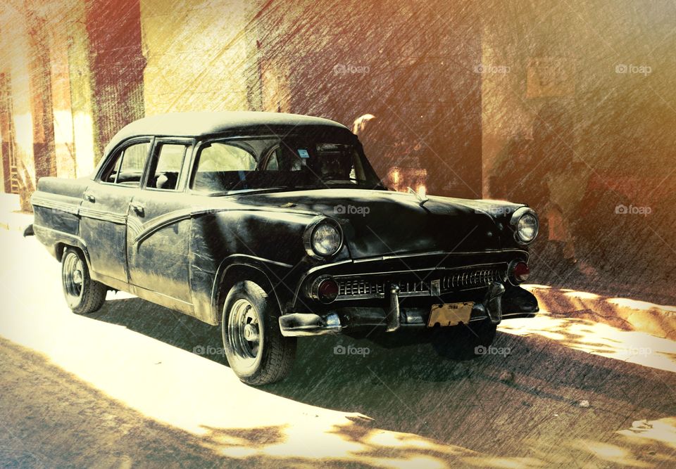 Havana, Cuba - 27 December 2013: Classic American car on the street of old Havana, Cuba parked in front of colorful building.