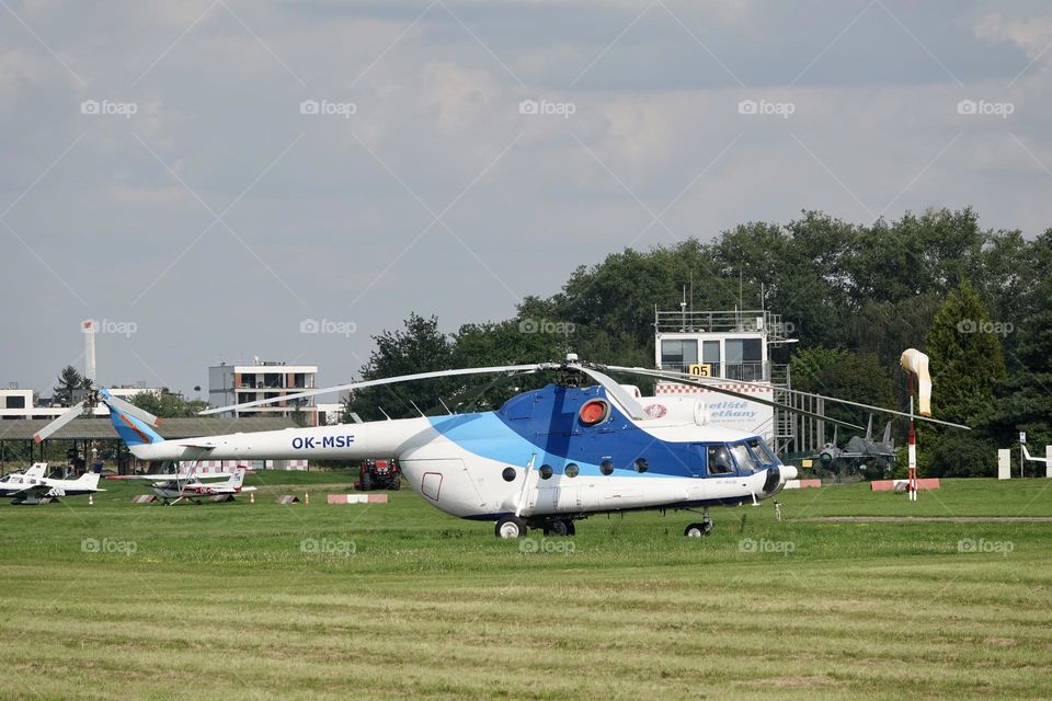 Blue and white Mil Mi-8 MSB helicopter on green grass on airport in Letnany, Prague, Czech Republic.