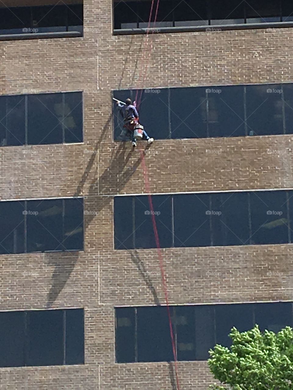 Duplicate photo of a crazy individual who was suspended in air cleaning windows while we all go home 