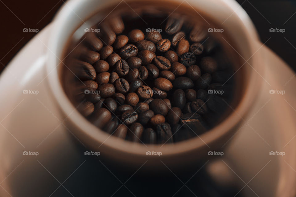 reflection of roasted coffee beans at coffee cup . Close up.  morning coffee concept