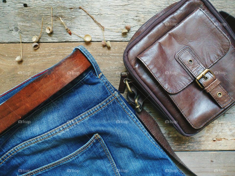 Blue jeans, leather belt and brown leather bag