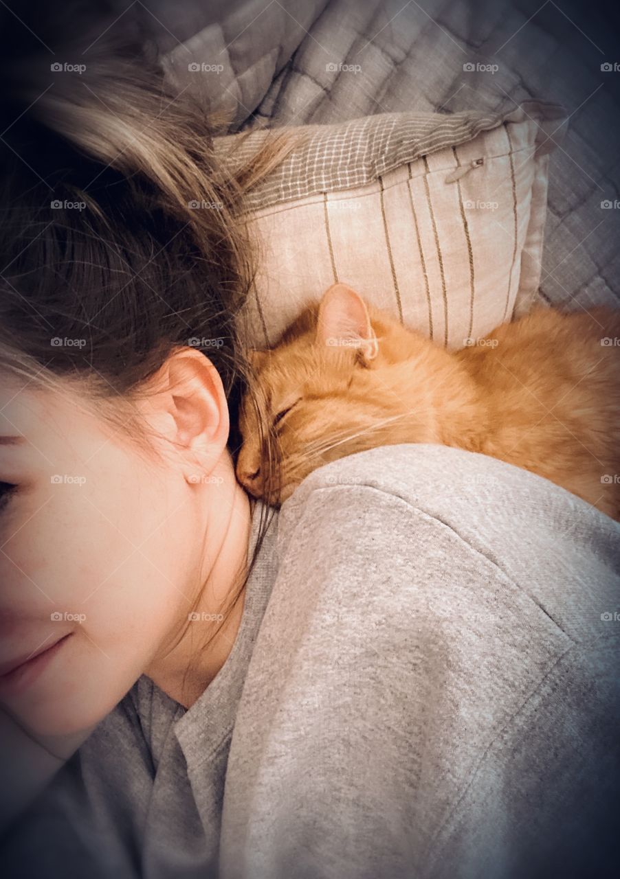 A small tabby rescue kitten snuggles in tight for a nap on their favorite human