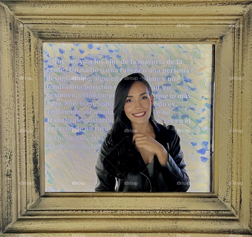 A smiling woman in a big wooden portrait 