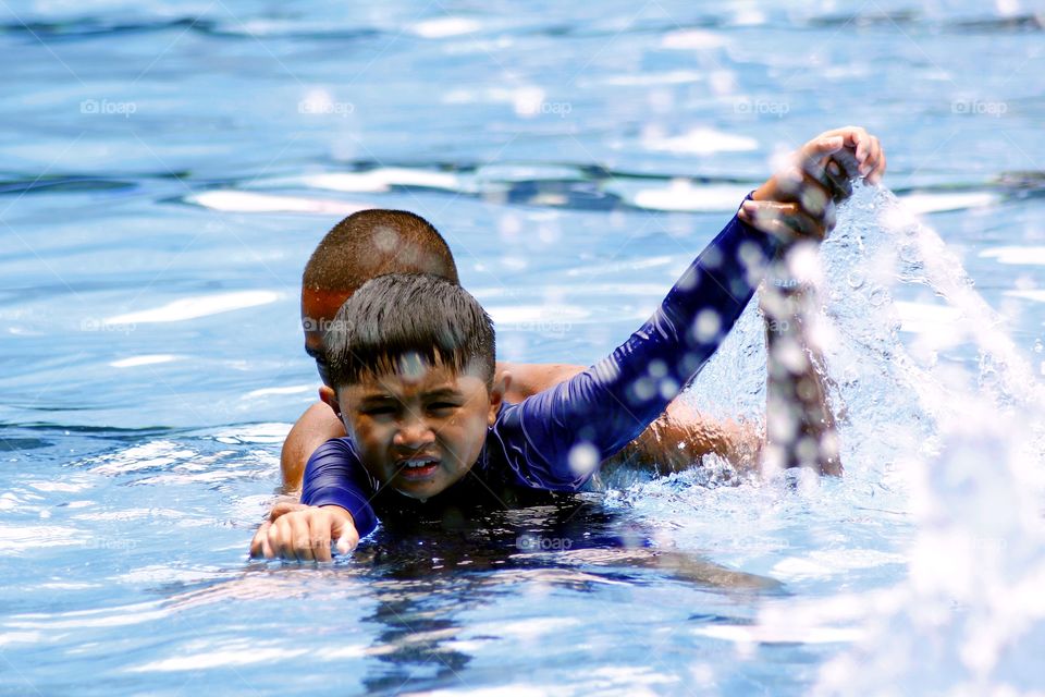 a child is taught by a swimming coach how to swim