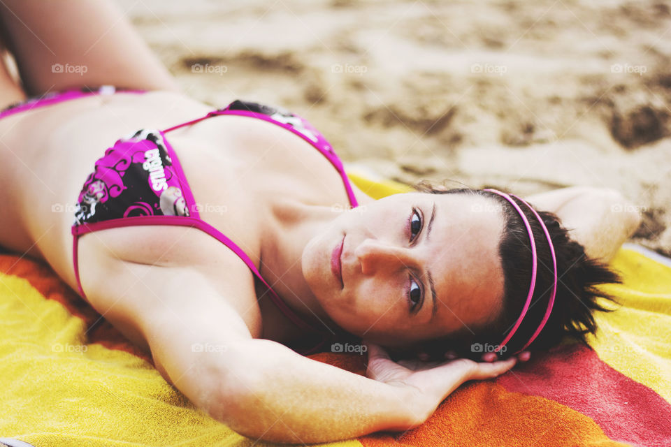 Young woman lying on blanket at beach