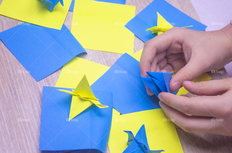 a child makes a crane out of paper