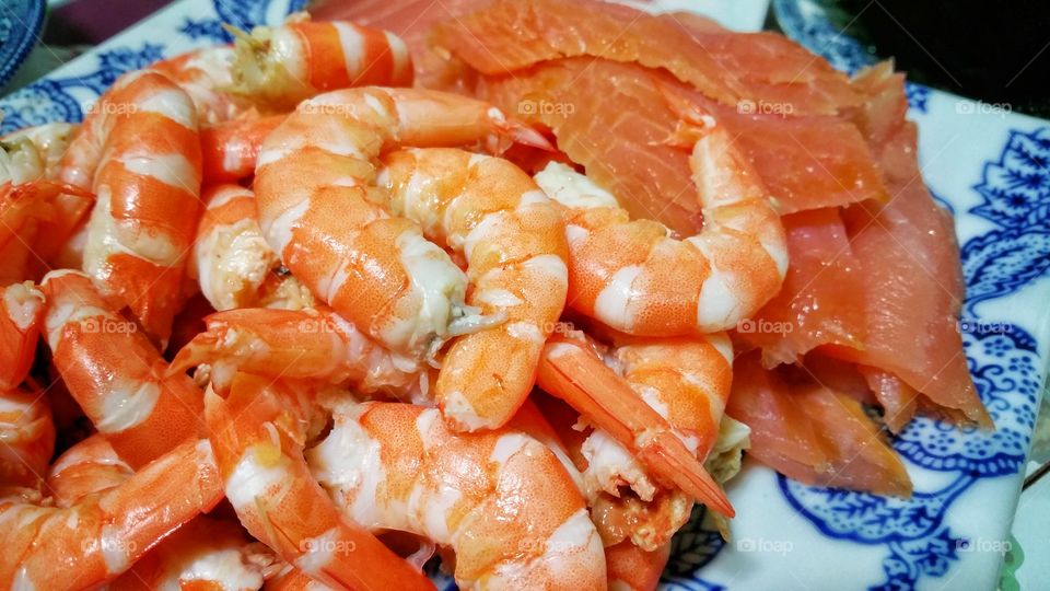 Freshly cooked prawns and smoked salmon displayed on a plate. Ready for consumption.
