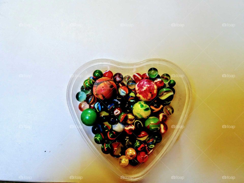 A heart made of marbles and  bouncy balls