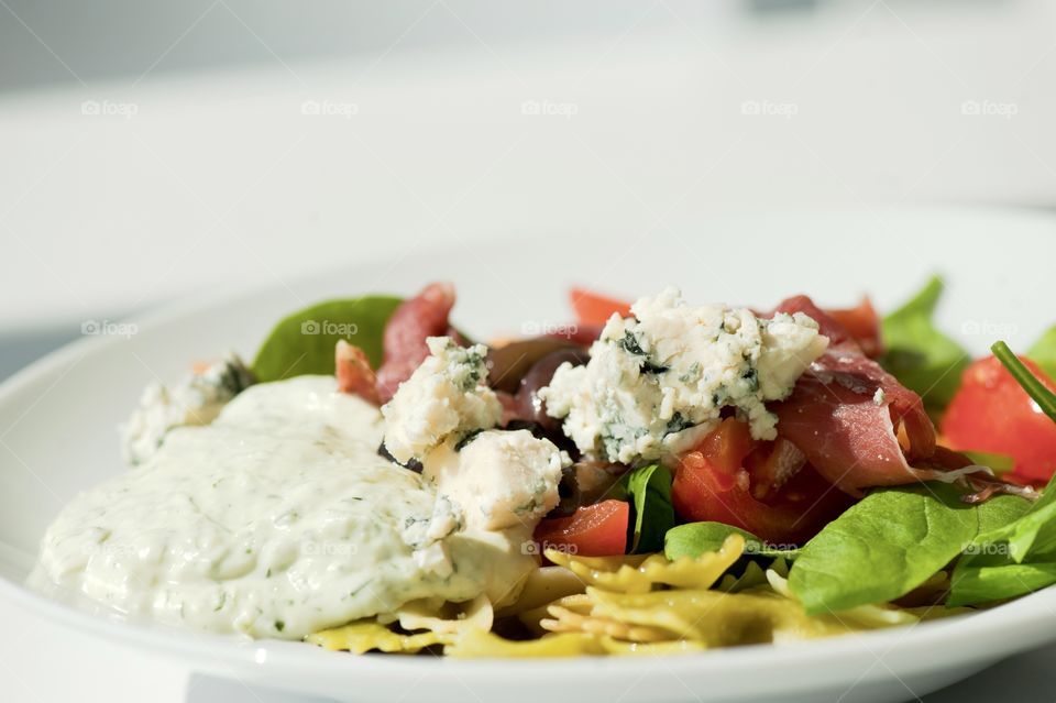 close-up of a young man eating a salad in a light kitchen