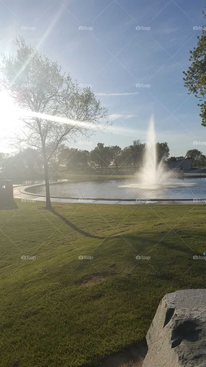 beautiful view of the water dancing from the fountain, illuminated by the rays of a setting sun.
