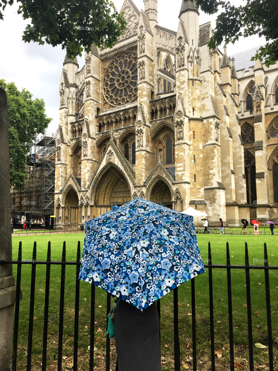 A blue floral umbrella in front of the Westminster abbey in London 