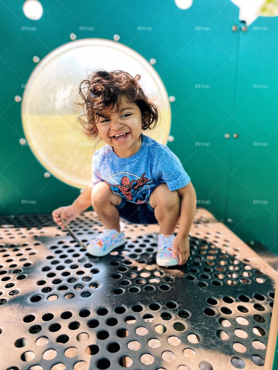 Toddler laughing on playground, toddler smiling at park, toddler showing happiness outside, toddler is happy outside, toddler at parks outdoors, toddler’s happy facial expression, toddler girls smiling face, expressing happiness with toddlers