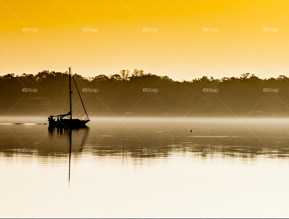 Sailboat silhouette sailing in the sunrise