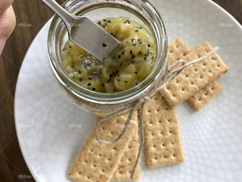 Homemade Kiwi jam and crackers on a plate 