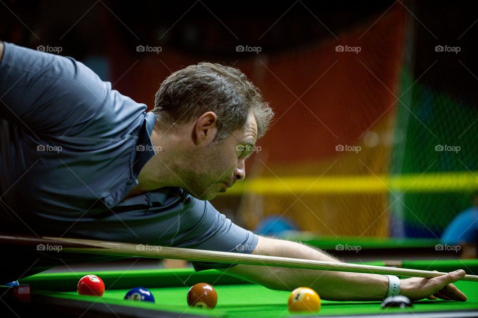 a close up of man playing billiards