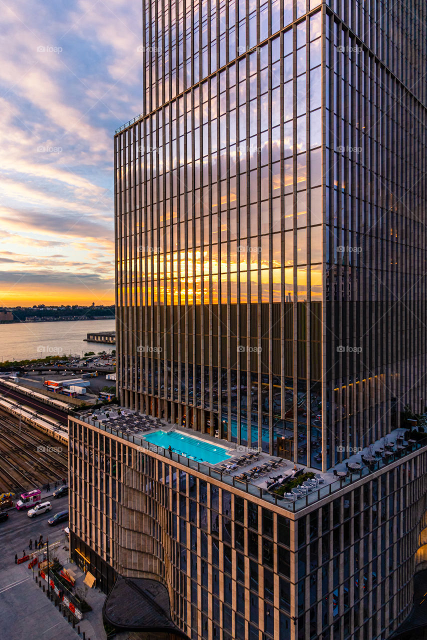 Glass building with symmetrical vertical lines reflecting a beautiful sunset in the windows. 