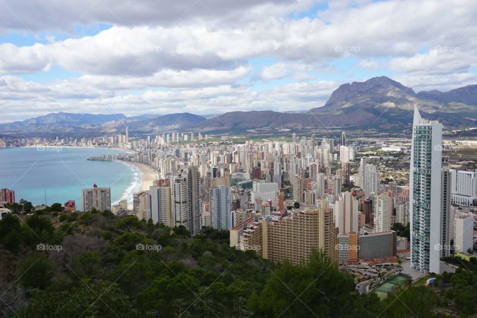 Beach#city#buildings#mountains#sky#view#clouds