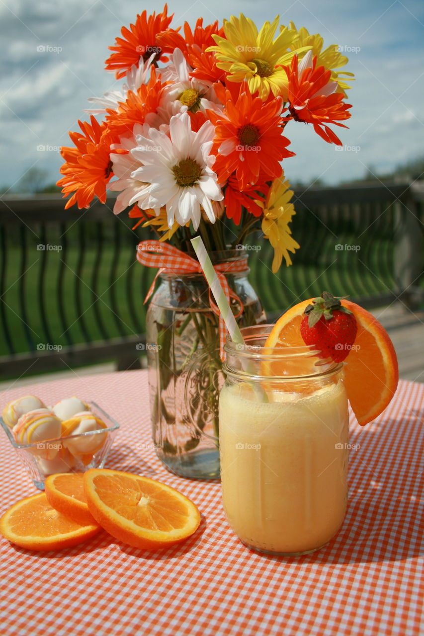Orange smoothie in jar on table