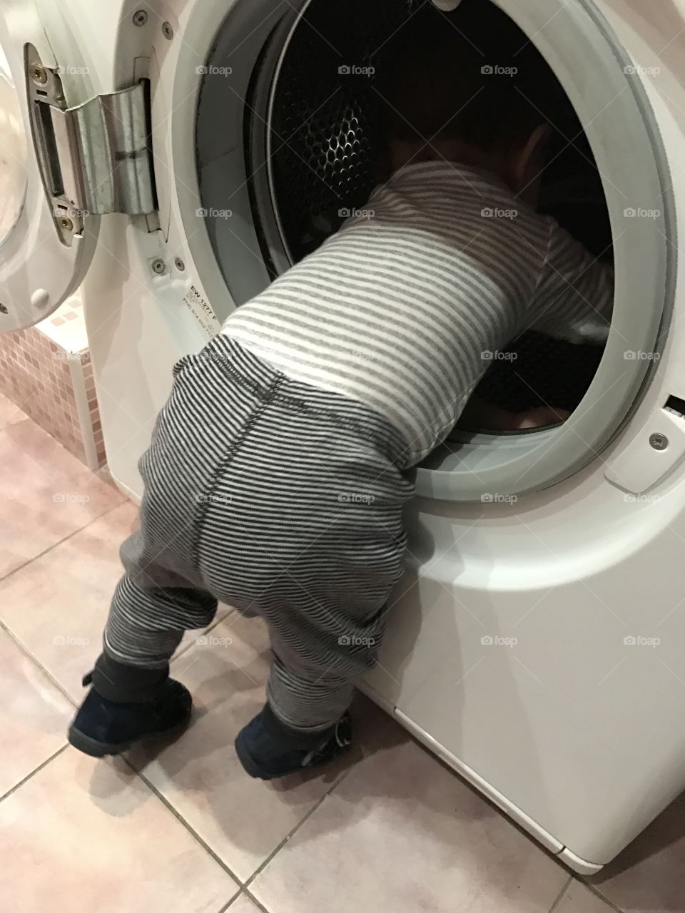A child climbing inside a washing machine