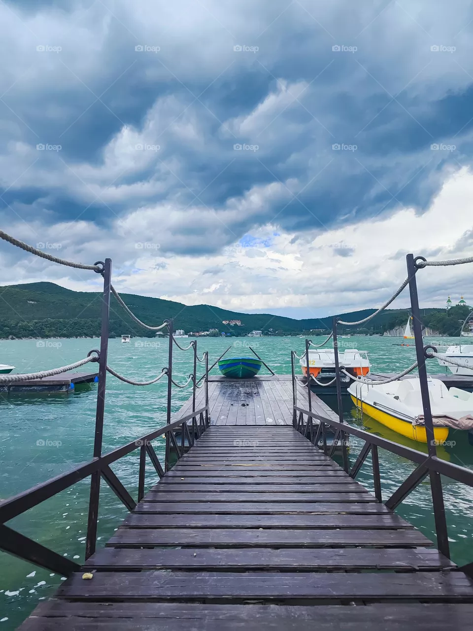 A boat on the pier against the background of dark clouds
