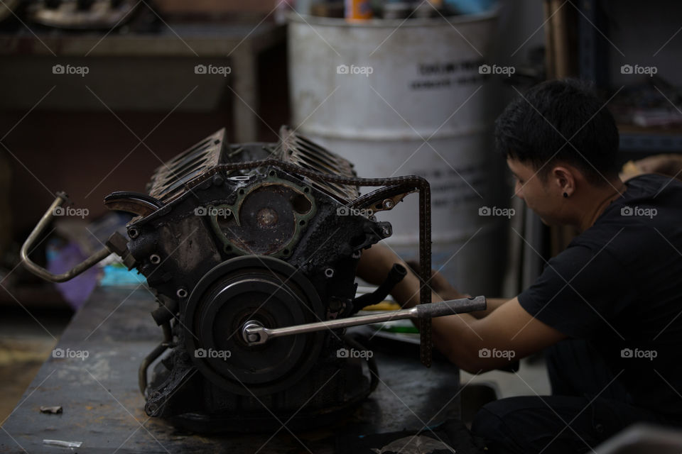 Technician fixing the car engine in the garage 