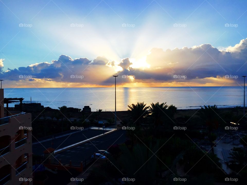 sunrise in a small town ,with rays pearcing the clouds