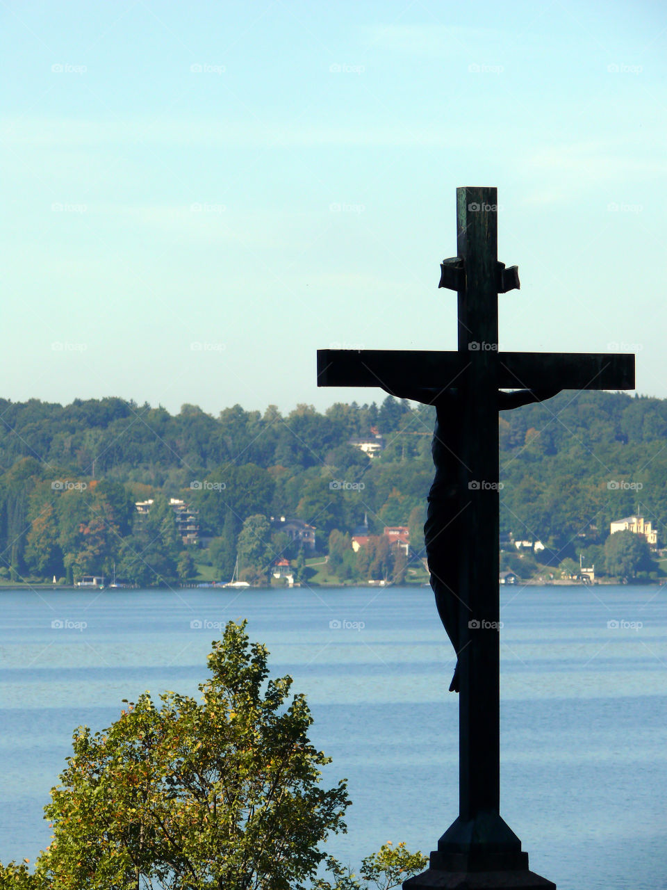 Silhouette of Christ and cross with Starnberg lake in background in Starnberg, Germany.