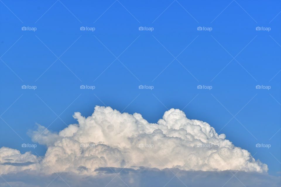 Beautiful puffy white cloud on a background of blue sky