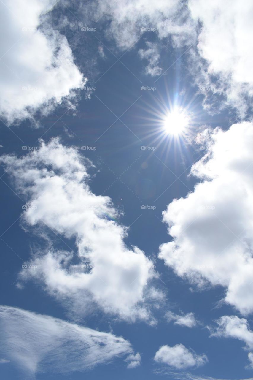 midday sun with two type clouds