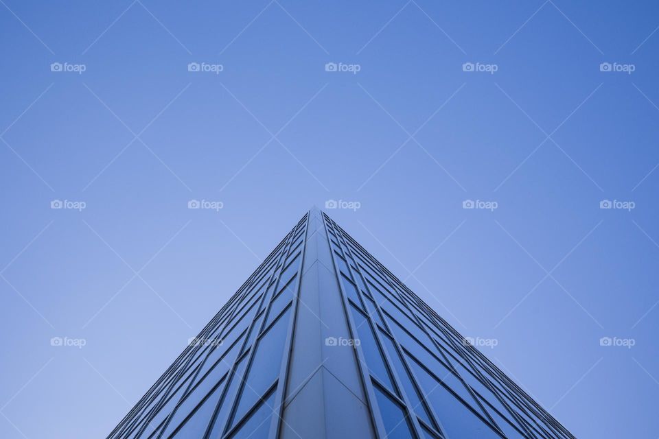 low angle view of modern office building against blue sky