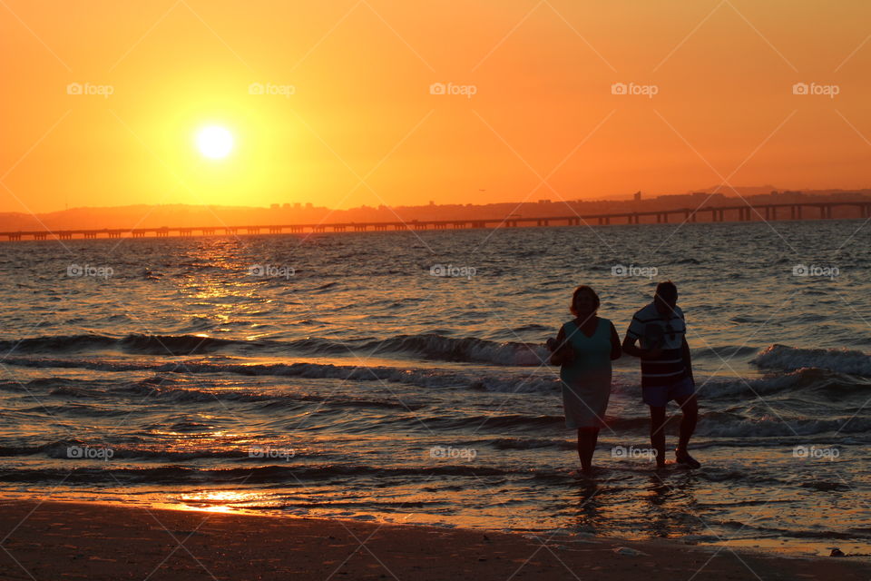 Couple walking in the beach during a beautiful sunset. Love, romance, beauty 