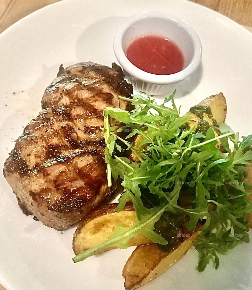 Appetizing steak with potatoes and arugula