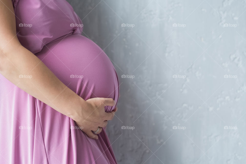 Beautiful pregnant woman in pink dress 