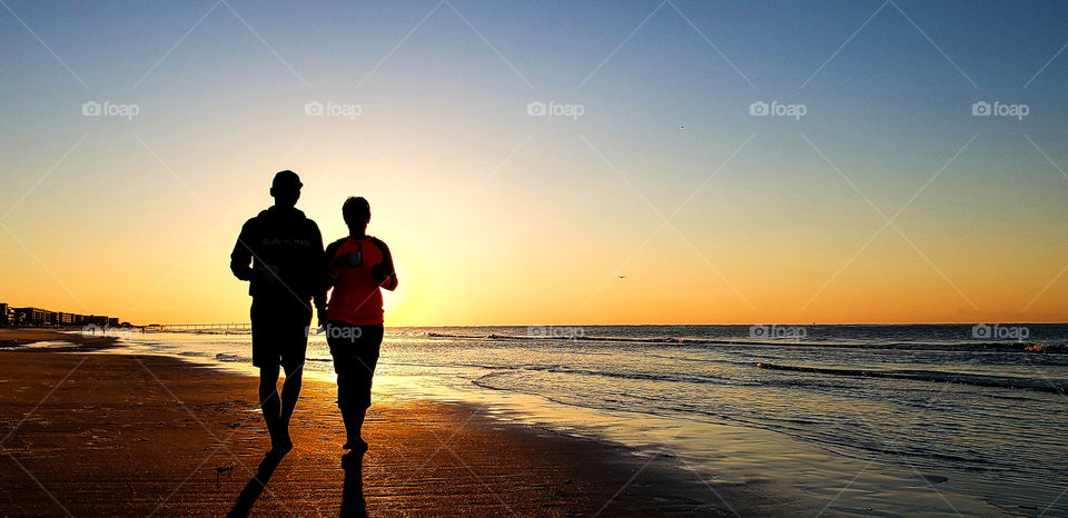 Active baby boomers walking on beach.
