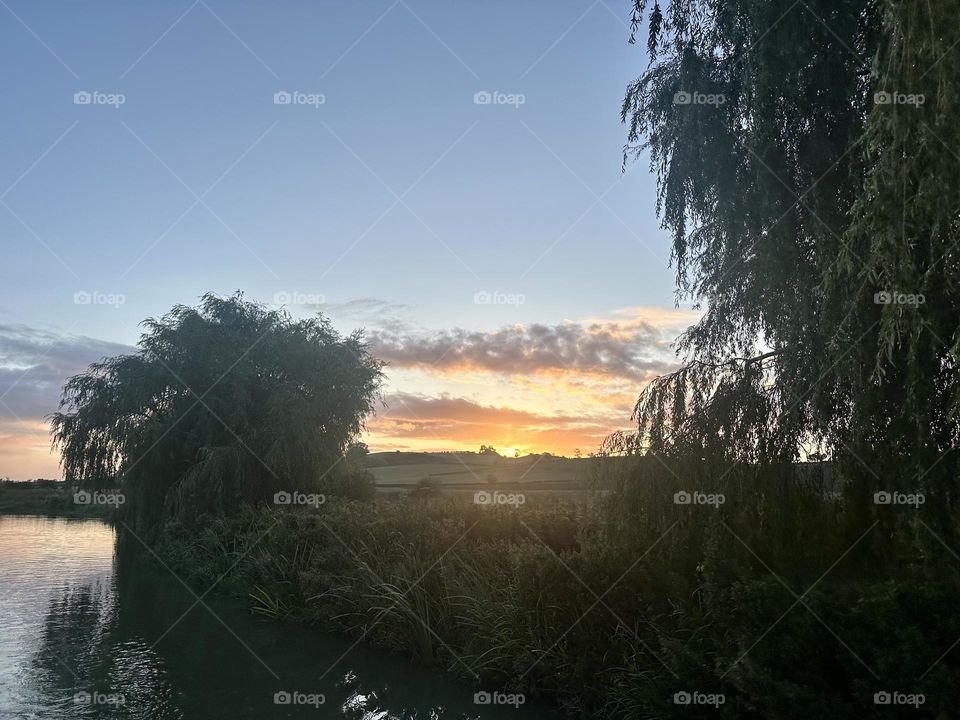 Early morning start for last day narrowboat cruising along Oxford canal going back to Napton beautiful sunrise sky horizon 