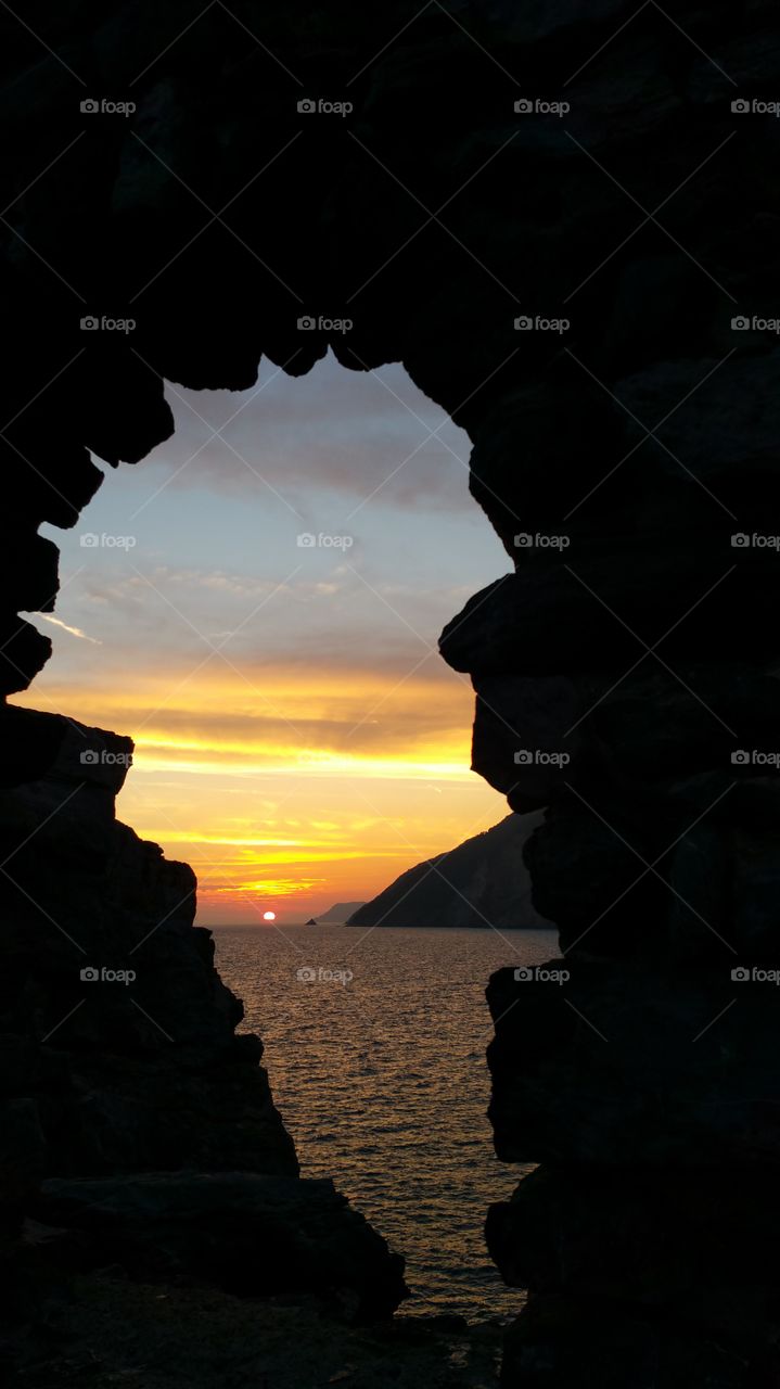 Sea seen through cave at sunset