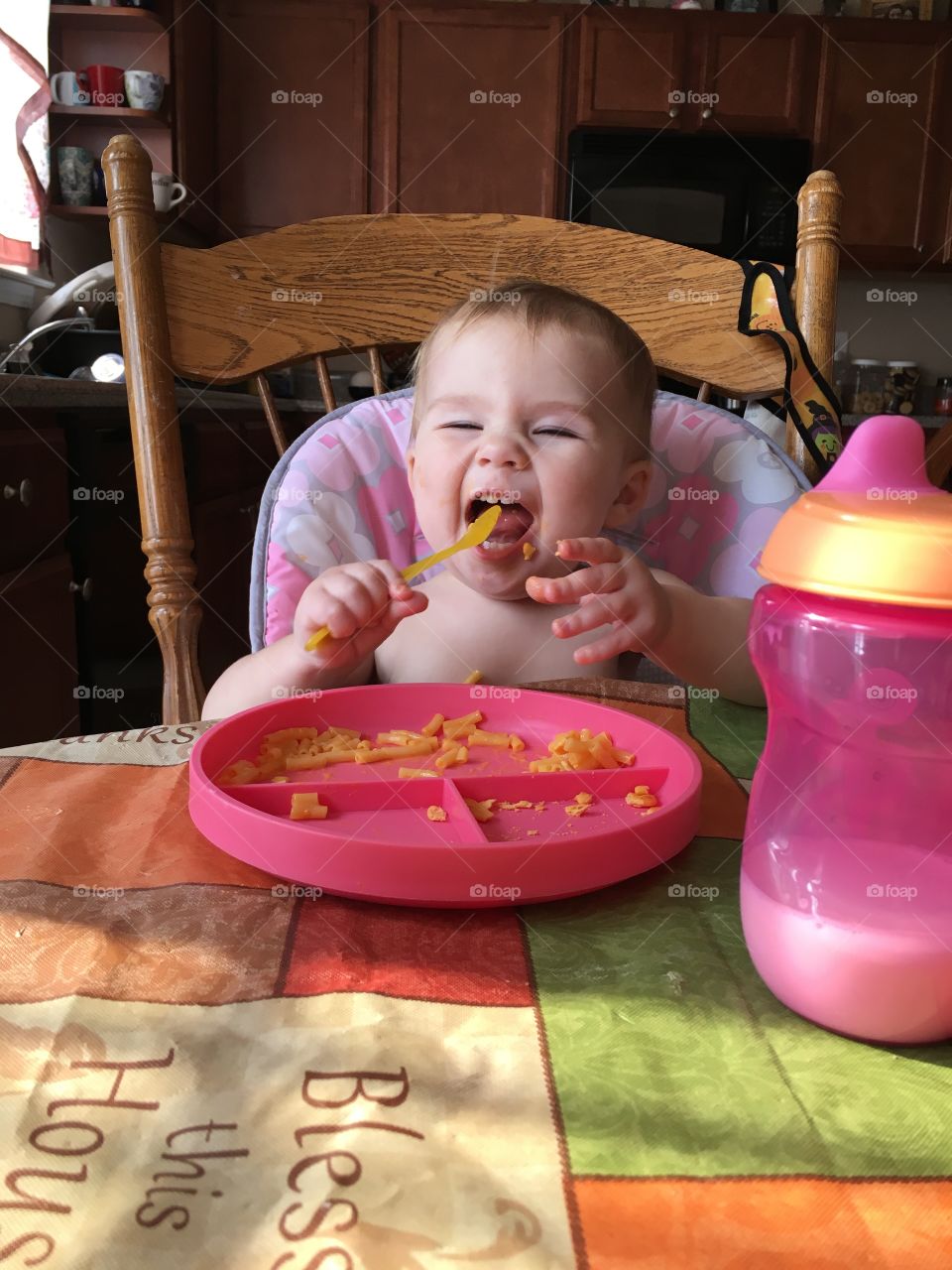 Little baby eating pasta with spoon