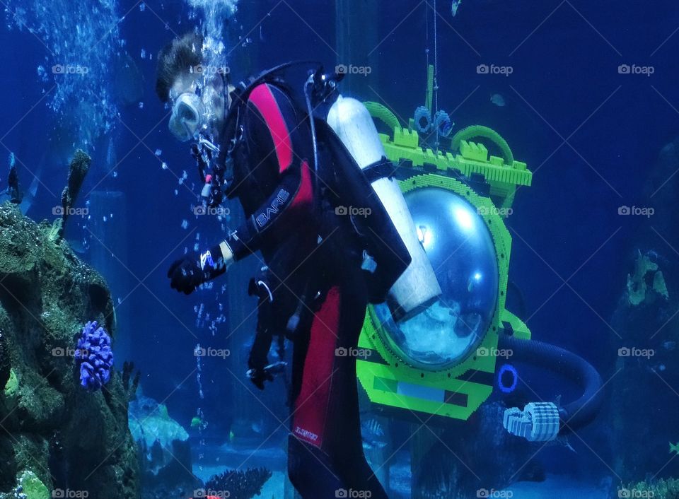 Underwater Exploration. Scuba Diver In Coral Reef With Yellow Submarine
