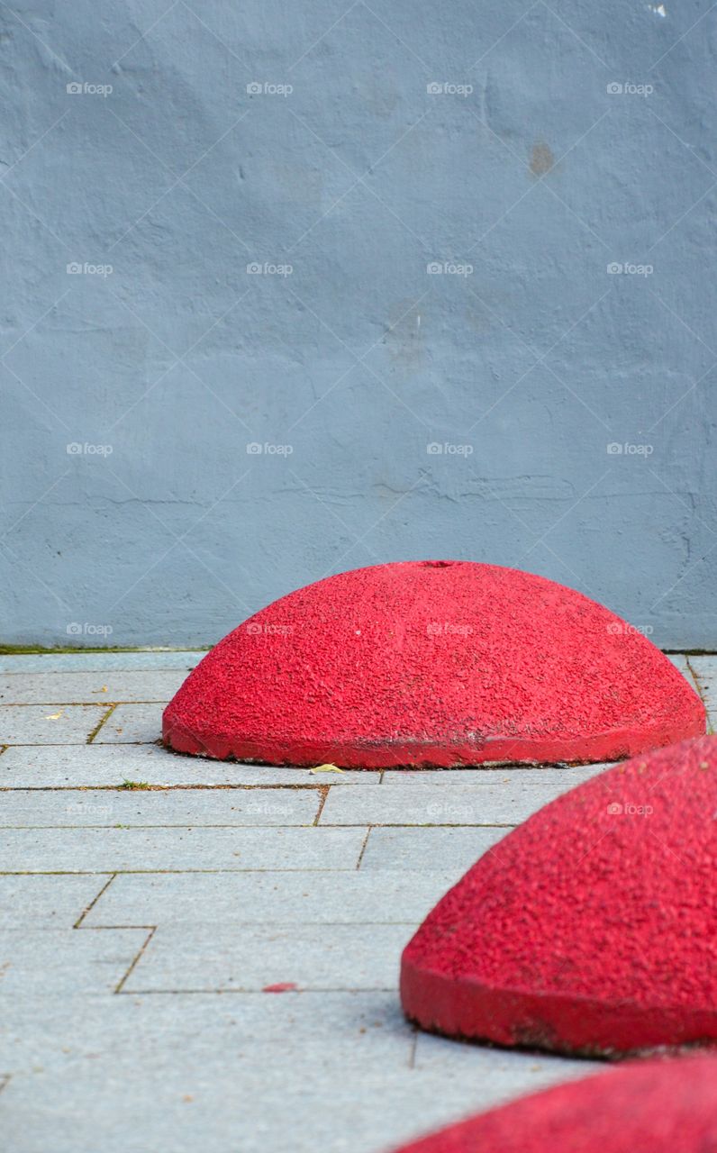 Red stone sculptures on pavement 