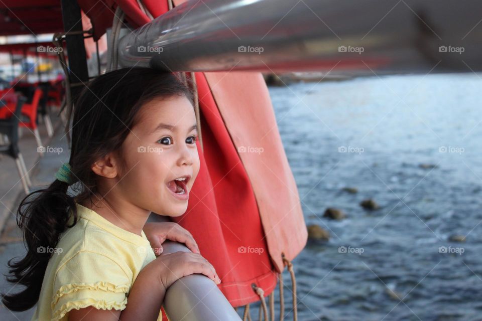 Surprised Asian girl standing near the railing