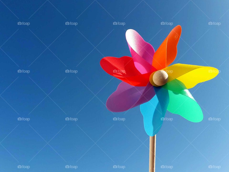 multi colored pinwheel in front of blue sky